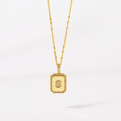 Timeless, elegant, and classy - our gold initial pendant necklace gives a personal touch to any outfit. This 18-20" personalized necklace features a gold pendant with an initial that is framed by shimmering crystals and the empowering message “I am Beautiful, Resilient, Strong, Enough, Loved ”is delicately engraved on the back. Tough days don't stand a chance against your inner fire! Wear this gold initial necklace to remind yourself that you are beautiful, loved, enough, strong, and resilient t Gold Monogram Initial Pendant Necklace, Elegant Gold Initial Necklace With Name Detail, Gold Initial Necklace With Rectangular Pendant, Gold Tarnish Resistant Initial Necklace With Rectangular Pendant, Silver Gold Plated Initial Necklace, Silver Gold-plated Initial Necklace, Luxury Personalized Gold Initial Necklace, Elegant Gold Initials Necklace, Gold Initials Name Necklace