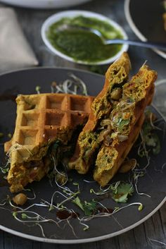 two waffles on a plate with some green sauce