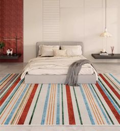 a large bed sitting on top of a white floor next to a red and blue rug