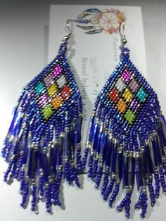 These Earrings are Handmade by Me, Native American Dangle Type Pierced Earrings, Sterling Silver Hook Wires with Rubber Backs. They are 3 inches long and 1 1/2 inches wide. They are " Bordered in Royal Blue Iris beads, and have "12mm Royal Blue and Silver Twisted Bugle Beads". There are a rainbow of colored triangle's which is considered the Ladder. Please take a close look at my work. Thank You So Very Much for your Interest Royal Blue Beaded Earrings, Traditional Handwoven Blue Beaded Earrings, Blue Beaded Fringe Dangle Jewelry, Blue Bohemian Beaded Fringe Earrings, Unique Blue Beaded Earrings Nickel-free, Blue Iris, Bugle Beads, Pierced Earrings, Brick Stitch