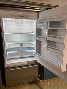 an open refrigerator with its door wide open and no ice maker on the side, in a kitchen