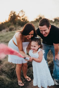 a man and woman are playing with a small girl