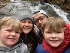 a group of people standing next to each other near a waterfall