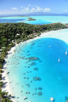 an aerial view of the beach and lagoons in the tropical island with sailboats