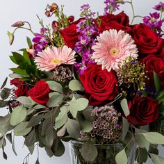 a vase filled with lots of red and pink flowers