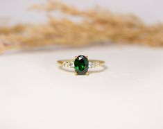 a green and white ring sitting on top of a table next to some dried grass