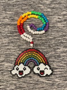 the beaded necklace has two skulls on it and a rainbow in the middle with beads