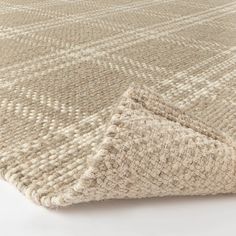 an area rug with a white and beige pattern on the bottom, it is folded in half