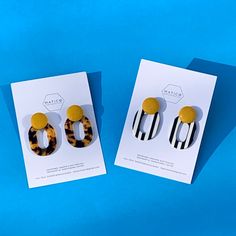 two pairs of animal print earrings sitting on top of a card