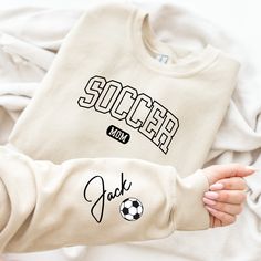 Key Features:Personalized Soccer Mom Sweater, Custom Soccer Mom Sweatshirt, Customized Soccer Mom Hoodie, Gift For Soccer Mom, Soccer Mama Hoodie | HOW TO ORDER? || It's easy to place an order! Please check the theme, color, and size of all images in this listing. - From the drop-down menus, choose the size and color. - For personalization, fill in the blank box with your design color. Please look at the photos in this listing to see what colors are available. (Example: Design Color White) - Sel Sporty Fan Merchandise Winter Sweatshirt, Sportswear Long Sleeve Sweatshirt For Fans, Sporty Winter Fan Merchandise Sweatshirt, Long Sleeve Sportswear Sweatshirt For Fans, Sporty Crew Neck Hoodie With Lettering, Sporty Cotton Sweatshirt With Name Print, Sporty Long Sleeve Sweatshirt With Name Print, Sporty Fleece Sweatshirt For Fans, Team-colored Long Sleeve Sweatshirt With Letter Print