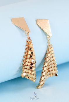 Make way for a statement like no other. These sparkling gold plated drop earrings instantly elevate any look with geometric sparkle that dances in the light. Crafted from gold plated brass for a high shine that lasts, the triangular studs frame a shimmering handkerchief design that will have heads turning. Diamond-shaped Gold Jewelry For Party, Gold Diamond-shaped Party Jewelry, Trendy Gold Triangle Earrings, Gold Geometric Jewelry For Party, Triangle Gold Metal Earrings, Gold Triangle Metal Earrings, Geometric Gold Earrings For Party, Gold Geometric Earrings For Party, Handkerchief Design