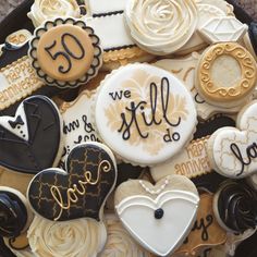 decorated cookies in the shape of heart and love words are arranged on a platter