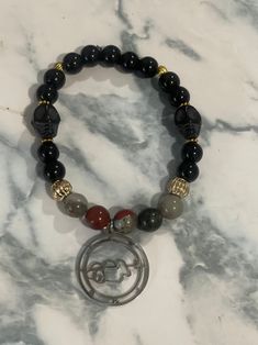 Inspired by the popular Demon of Wealth, King Clauneck, this genuine gemstone beaded bracelet is perfect for devotional worship or for anyone curious about Demonolatry.  It features 8mm Bloodstone beads that are paired with black Howlite skull beads and 8mm Black Agate beads. They are accented with gold tone spacer beads and a light weight stainless steel Clauneck Sigil charm.  It is secured on a durable elastic cord that is available in your choice of sizes from 6-9" in length to ensure a perfect fit. Clauneck Sigil, Skull Beads, Money Spells, Beaded Skull, Gemstone Beaded Bracelets, Morning Wishes, Black Agate, Good Morning Wishes, Agate Beads