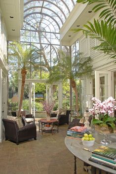 a living room filled with lots of furniture under a large glass ceiling covered in plants