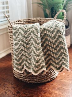 two green and white knitted towels in a basket