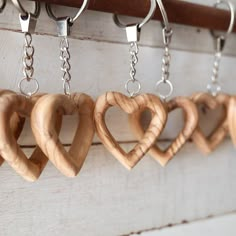 several wooden hearts hanging from hooks on a wall