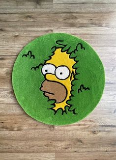 a rug with the face of homer simpson in green and yellow on a wooden floor