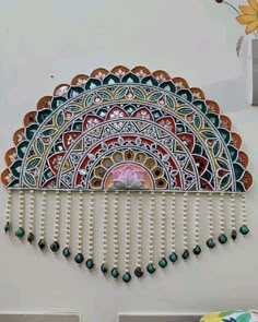 a decorative wall hanging on the side of a white wall