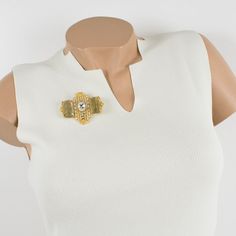 This lovely Gianfranco Ferre couture pin brooch features a dimensional gilt metal geometric shape, all paved with crystal clear rhinestones and topped with two massive champagne resin cabochons. A security closing clasp at the back with the Ferre, Made in Italy hallmark underside. Measurements: 2.50 in wide (6.3 cm) x 2.07 in high (5.2 cm).  Please see the measurements noted above in the description for the best approximate dimensions. Elegant Yellow Gold Brooches For Party, Elegant Yellow Gold Party Brooches, Luxury Rhinestone Brooches For Formal Occasions, Luxury Rhinestone Brooch For Formal Occasions, Elegant Gold Jeweled Brooches, Gold Evening Brooch Jewelry, Gold Jeweled Brooch For Formal Occasions, Luxury Gold-tone Brooch Jewelry, Gold Art Deco Brooches For Evening