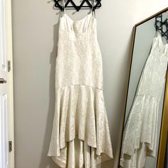 a white dress hanging on a wall next to a mirror