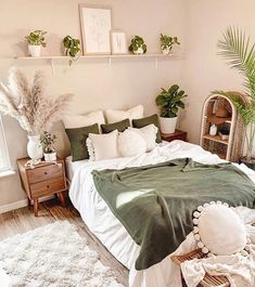 a bedroom with white and green decor on the walls, bedding, rugs and plants