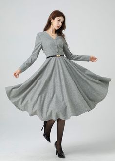 Stay stylishly snug this winter with a light grey wool swing dress. This dress is cinched at the waist with a hemline that can also be turned up beautifully, and has a buttoned front to accent the v-neck. Pair this dress with heeled ankle boots for a sophisticated look. Details: * 30% wool, 30% fiber, 40% polyester * fully satiny lining, more nice to the touch body * V neckline dress * Long sleeves dress * Two side seam pockets * Right zipper closure * Button front * Fit and flare dress * Midi w Gray A-line Winter Dresses, Knee-length Buttoned Midi Dress For Winter, Winter Knee-length Midi Dress With Buttons, Winter V-neck Midi Dress For Workwear, Winter A-line Midi Dress With Buttons, Wool Long Sleeve Midi Dress For Spring, Classic A-line Winter Dress, Classic V-neck Winter Dress, Classic Winter Dresses With Buttons