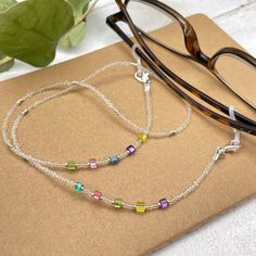 Colorful and bohemian eye glasses necklace chain in crystal clear tones with delicate multicolor flashes and silver notes, featuring small cubic zirconia charms. The necklace is made with Preciosa Czech crystal seed beads, tiny silver plated crystal seed beads and delicate colorful cubic zirconia crystal beads. Paired with tiny, delicate silver plated crystal beads, this handmade eyeglass chain will definitely create a unique look. This eyeglass lanyard is made on strong quality beading wire wit Beaded Glasses Chain, Beaded Glasses, Glasses Necklace, Grandma Birthday Gift, Eyeglasses Chain, Rainbow Sunglasses, Sunglasses Necklace, Glasses Chains, Birthday Gifts For Grandma