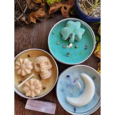 three bowls filled with food sitting on top of a wooden table next to plants and leaves