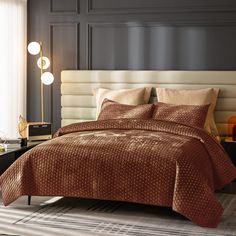 a bed with a brown comforter and pillows