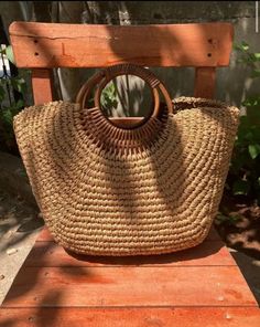 a straw bag sitting on top of a wooden chair