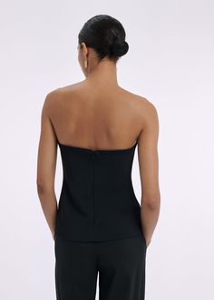 Strapless bustier top with interior boning detail, slim silhouette, and hip length for easy tucking. Details Strapless black bustier top Fitted silhouette Flexible boning Invisible back zip 97% Viscose 3% Elastane 1178MBND-ESSN Fits true to size. Take your normal size. Model is 5'10" and wears a size Small. Chic Sleeveless Tube Top For Formal Events, Chic Sleeveless Tube Top For Formal Occasions, Bandeau Tube Top With Fitted Bodice For Night Out, Sleeveless Elastane Tube Top For Party, Chic Tube Top With Boned Bodice For Night Out, Fitted Bodice Bandeau Tube Top For Night Out, Chic Boned Bodice Tube Top For Night Out, Elastane Tube Top For Party, Fitted Strapless Top With Boned Bodice