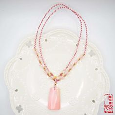 "Designed as a Chinese popular decoration of Peace Plate Pendant(無事牌), this featured queen conch shell pendant has a cultural meaning: \"peace without disaster\". Queen conch shell is a beautiful organic gemstone with soft tone from pink, golden to white. The paired necklace is braided with rose quartz beads and high-quality cords. The overall design embodies implicit and plain style. So this conch braided cord necklace is a wonderful jewelry to wear every day. 🌷Item Specifics ❊ Queen Conch She Handmade Pink Shell Necklace For Gift, Spiritual Shell Necklace As Gift, Pink Hand-strung Necklace As Gift, Pink Hand-strung Necklace For Gift, Pink Spiritual Beaded Necklace For Gift, Pink Spiritual Jewelry For Blessing, Pink Shell Necklace With Round Beads For Gift, Pink Shell Necklace With Round Beads As Gift, Pink Adjustable Shell Necklace As Gift