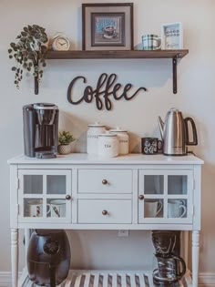 a white coffee bar with shelves on the wall above it and various items on top