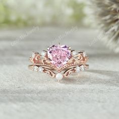 a ring with a pink diamond and pearls