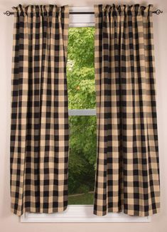 black and white checkered curtains hanging in front of a window with trees outside the window