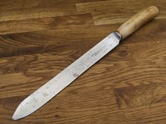 a large knife sitting on top of a wooden table