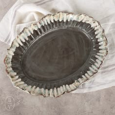 a black plate sitting on top of a white cloth