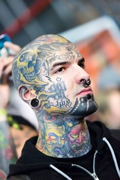 a man with tattoos and piercings on his face