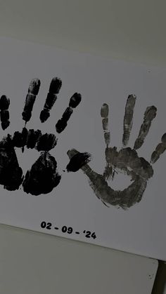 two handprints are shown on a white board with black ink in the middle