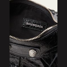 Balenciaga "Le Cagole" shoulder bag in lambskin leather  Features signature stud and buckle hardware; strass embellishment or metal hardware  Adjustable buckle shoulder strap Zip top closure  Lining: Cotton Approx. 6.3"H x 10.2"W x 2.7"D Spot clean Made in Italy Metal Hardware, Zip Top, Lambskin Leather, Leather Shoulder Bag, Balenciaga, Tops Designs, Shoulder Strap, In Italy, Buckle