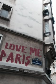 graffiti on the side of a building that says love me paris