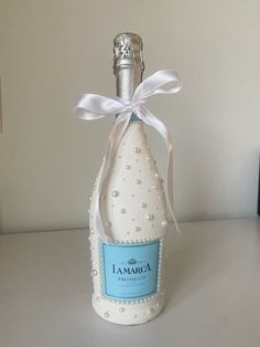 a bottle that is on a table with a ribbon around the top and bottom part