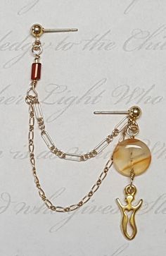 a pair of earrings with charms attached to them