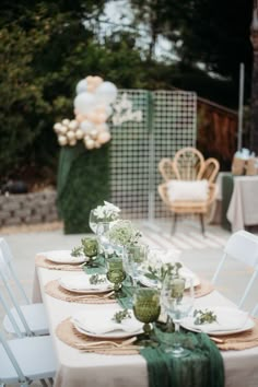 the table is set with white and green place settings