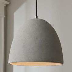 a gray light hanging from a ceiling in a room with white walls and window sill