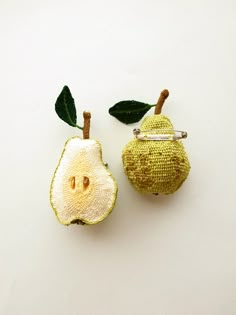 two pieces of fruit with green leaves on them