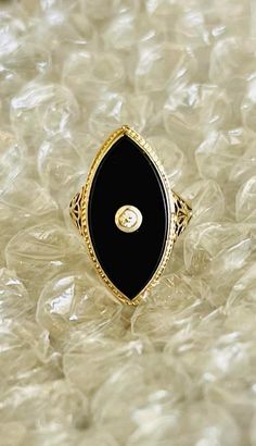 Antique Art Deco Ladies Marquis Ring.  14 K White and Yellow Gold.  Black Onyx with European cut diamond stone set in center.  Sleek, slender and stylish.  Beautiful hexagonal shape with open floral filagree on both sides.  Representing the most perfect example of the art deco period.  Good condition.  Normal wear.  Ladies size 5.  Can be resized.  Stone measures 7/8" Long. Elegant Diamond Ring With Black Enamel As Gift, Elegant Evening Diamond Ring With Gemstone, Elegant Black Enamel Diamond Ring For Anniversary, Elegant Black Enamel Jewelry For Anniversary, Elegant Black Enamel Jewelry For Wedding, Formal Black Ring With Single Diamond, Elegant Black Enamel Rings For Formal Events, Elegant Onyx Diamond Ring For Formal Occasions, Elegant Black Enamel Rings For Evening