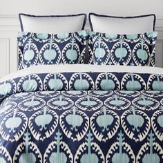 a blue and white bed with pillows on it