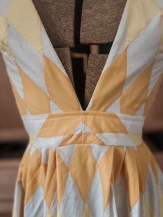 the back of a dress with an orange and white design on it's chest