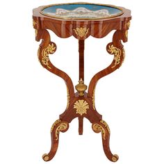 an ornately decorated wooden table with blue glass inlays and gold leaf accents